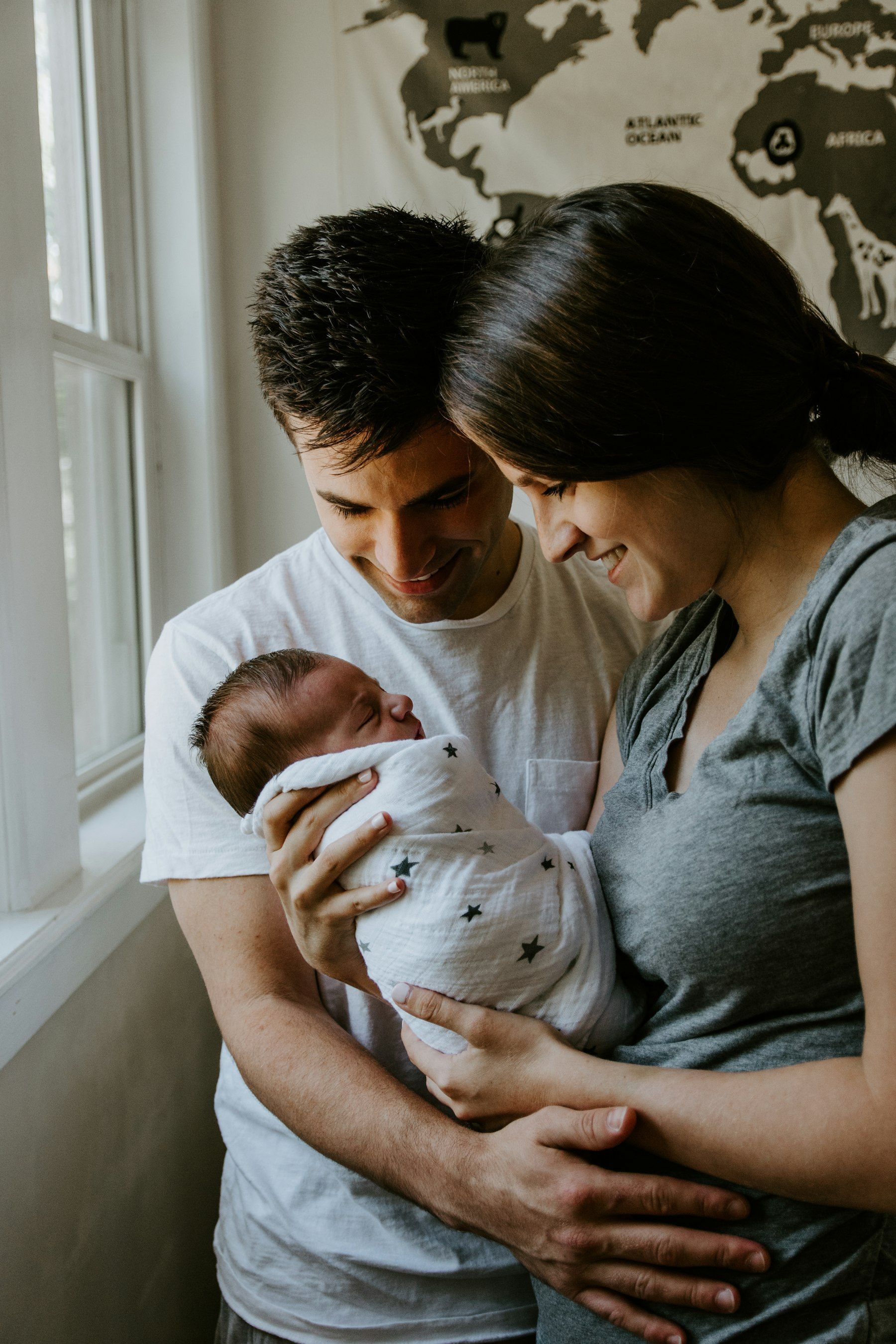 Eltern halten ihr neugeborenes Baby am Fenster