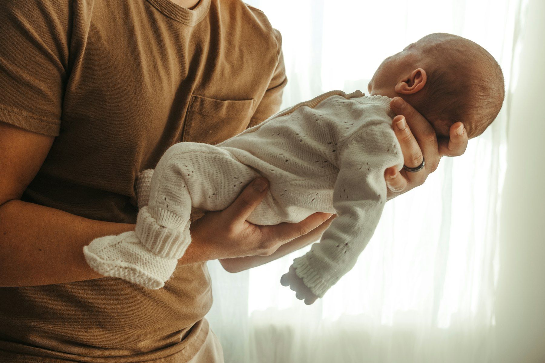 Ein Vater hält sein neugeborenes Kind